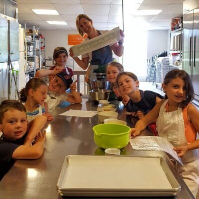 A group of children posing for a picture in a kitchen.
