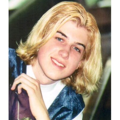 A young man with blonde hair is posing for a photo.