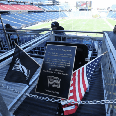 A patriotic plaque at a football stadium, featuring the American flag, commemorating the Army-Navy game.