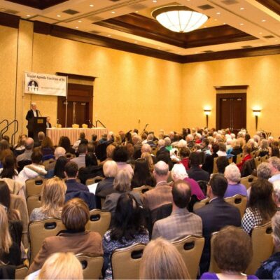 A large room full of seniors listening to a speaker.