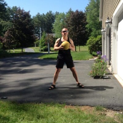 A man standing in front of a house with a yellow ball.
