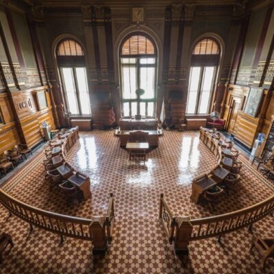 A large room with many windows and wooden floors.