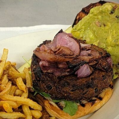 A burger with avocado on a plate recipe.