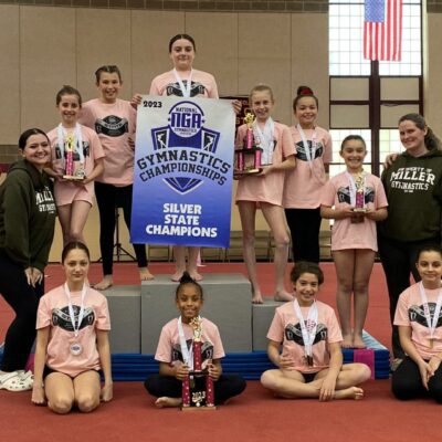A group of gymnasts posing with their trophies.