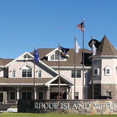 The front of a large building with flags on it.