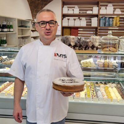 Baker holding a decorated birthday cake.