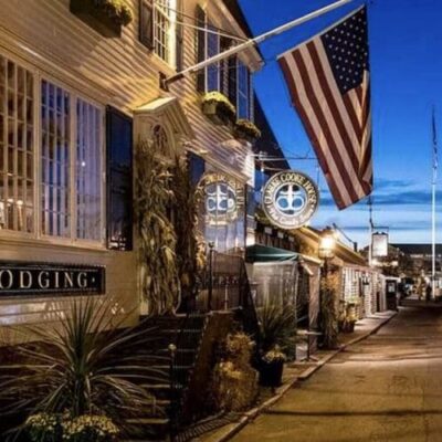 An american flag is flying in front of a building at dusk.