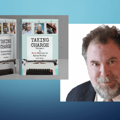 A man with a beard and glasses is standing next to a book cover.