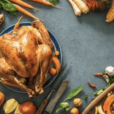 Thanksgiving turkey and vegetables on a blue background.