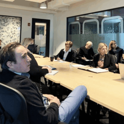 A group of people sitting around a table in a conference room.