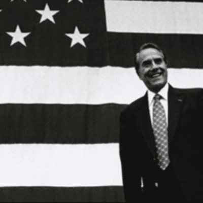President barack obama standing in front of an american flag.