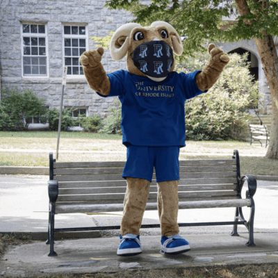 A mascot wearing a blue shirt on a bench.