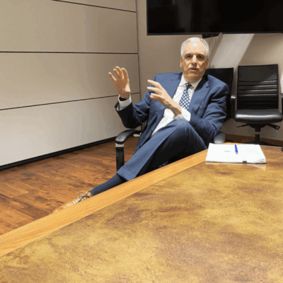 A man in a suit sitting in a conference room.