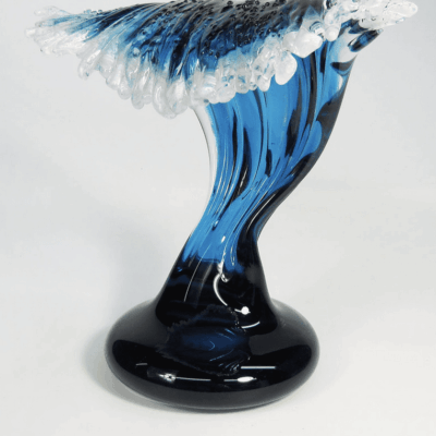 A blue and white glass sculpture on a stand.