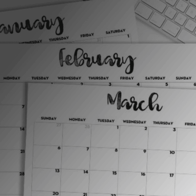 A printable calendar on a desk next to a keyboard.