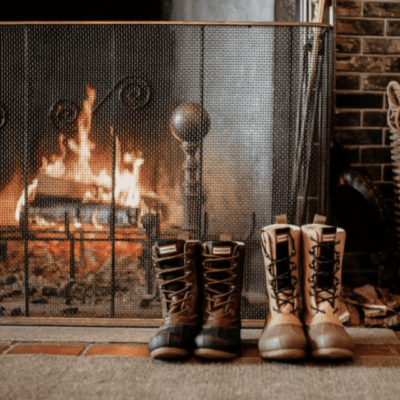 Winter boots in front of a fireplace.