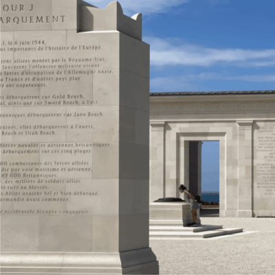 A statue of a soldier in front of a monument.