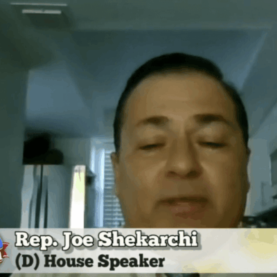 A man in a suit and tie is talking to a camera.