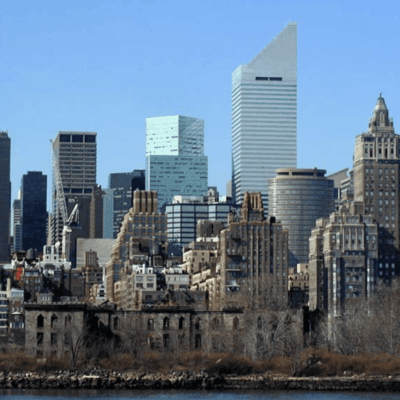 A city skyline with tall buildings and a body of water.