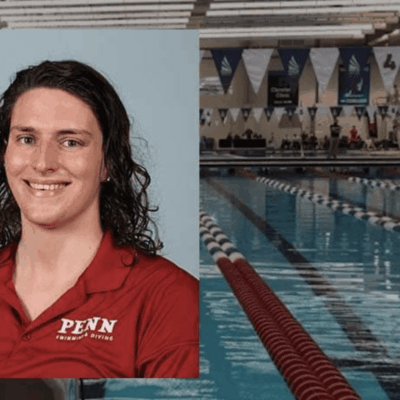 A woman in a red shirt is standing in front of a swimming pool.