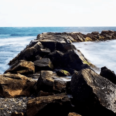 A rocky shore with waves crashing over rocks.