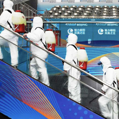 A group of people in protective suits walking down an escalator.