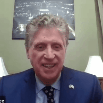 A man in a suit and tie is sitting in a room.