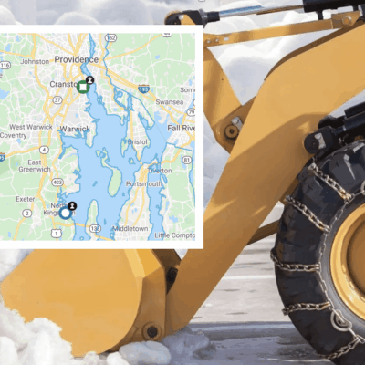 A bulldozer on a snowy road with a map in the background.