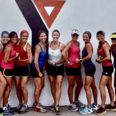 A group of women posing for a photo in front of a sign.