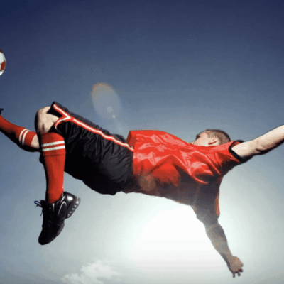 A soccer player kicking a ball in the air.