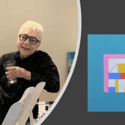 A woman sitting in a chair next to a piece of art.