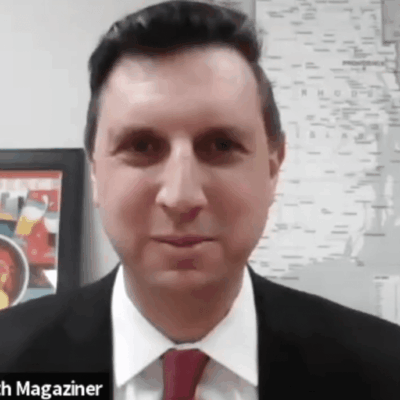 A man in a suit and tie in front of a map.