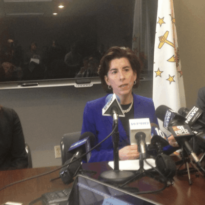 Three people sitting at a table in front of microphones.