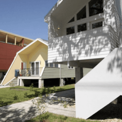 A row of houses with a car parked in front of them.