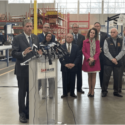 A group of people standing at a podium in a factory.