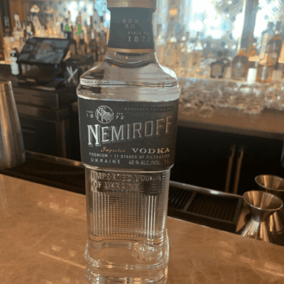 A bottle of nemroff vodka sitting on a bar.