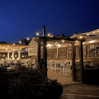 An outdoor dining area at night with string lights.