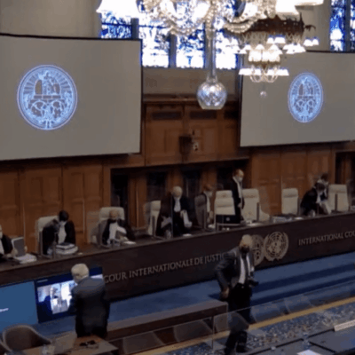 A courtroom with many people sitting around a table.