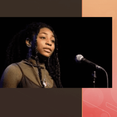 An image of a woman with dreadlocks in front of a microphone.