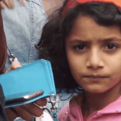 A girl with a pink headband is standing next to a group of people.