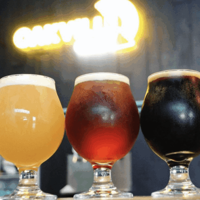 Three glasses of beer are lined up on a table.