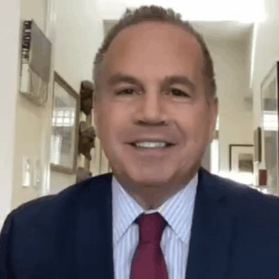 A man in a suit and tie is smiling.