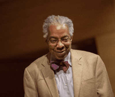 An older man in a suit and bow tie.