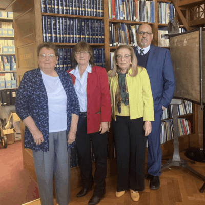 A group of people standing in front of a bookcase.