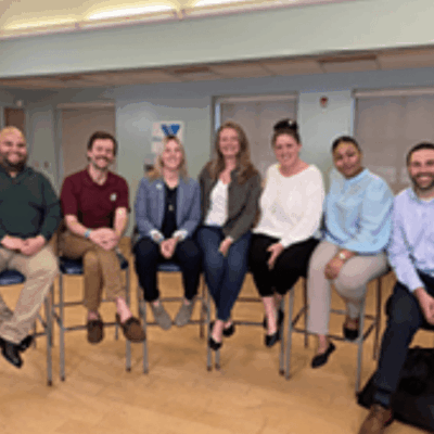 A group of people sitting on chairs in a room.