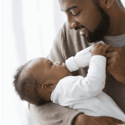A man feeding a baby with a bottle.