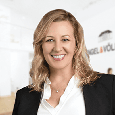 A woman in a business suit smiling in an office.