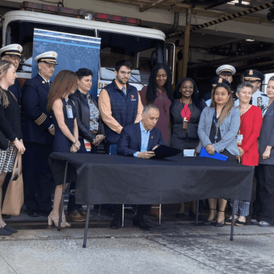 A group of people standing in front of a fire truck.