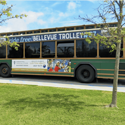 A green bus parked in a parking lot.