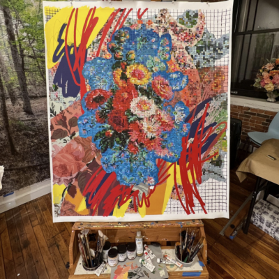 A painting of flowers on an easel in a studio.